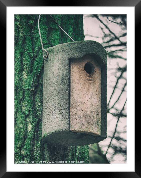 Vertical shot of a cylindrical concrete nesting box hanging from a tree Framed Mounted Print by Ingo Menhard