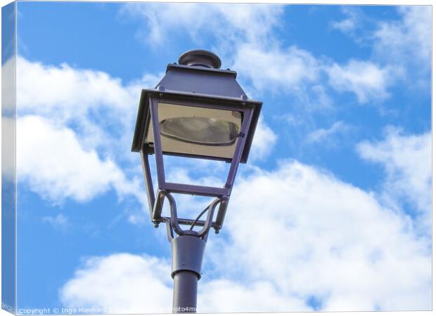 A low angle shot of an old metal street lamp against blue cloudy sky Canvas Print by Ingo Menhard