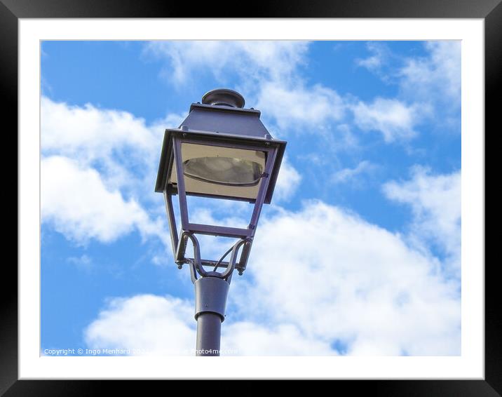 A low angle shot of an old metal street lamp against blue cloudy sky Framed Mounted Print by Ingo Menhard
