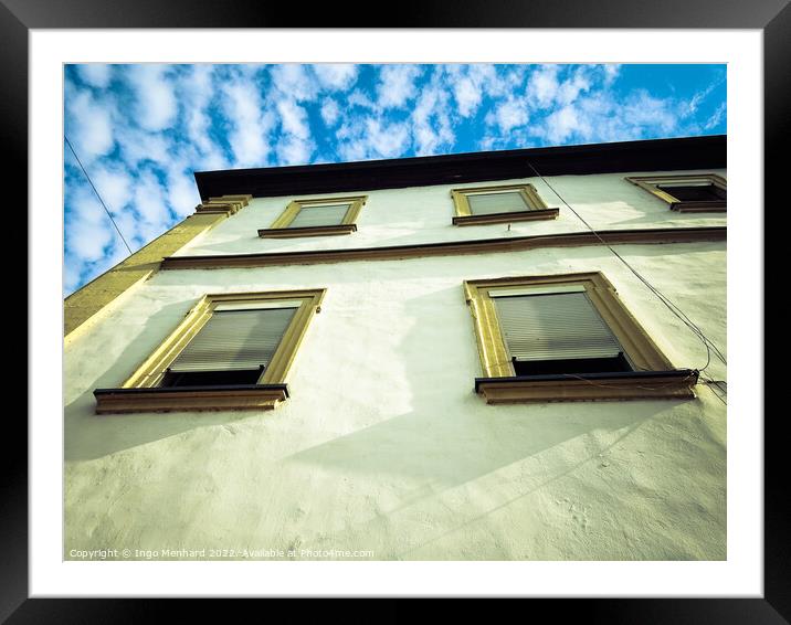 A low angle view of a building under a blue cloudy sky Framed Mounted Print by Ingo Menhard