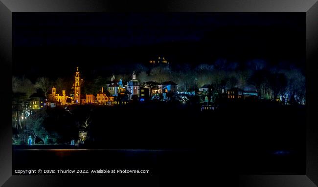 The lights of the Italianate village of Portmeirion illuminate the surrounding trees Framed Print by David Thurlow