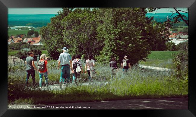 Group of wanderers at the Friedrichsberg in Bavaria walking to the village of Abtswind Framed Print by Ingo Menhard