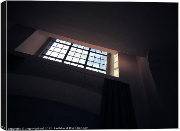 A low-angle shot of a small square window with bars in the dark room Canvas Print by Ingo Menhard