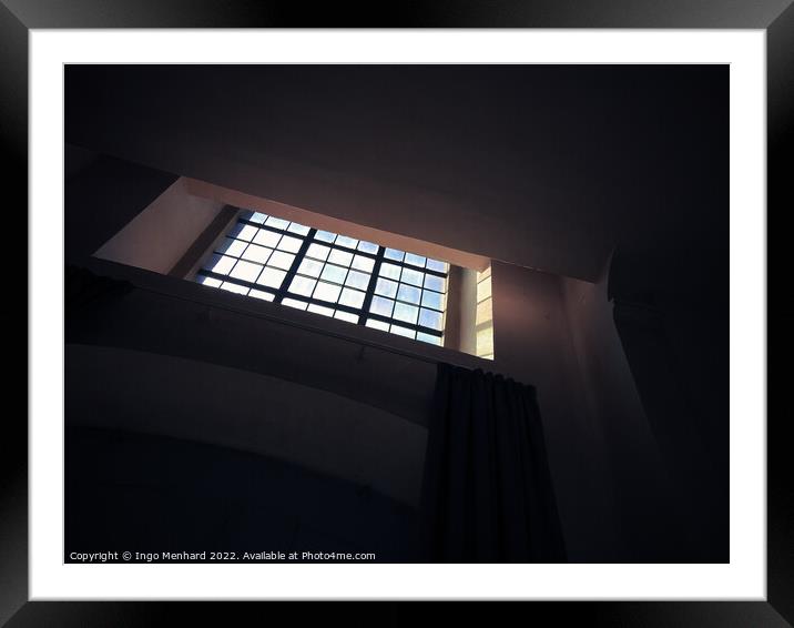 A low-angle shot of a small square window with bars in the dark room Framed Mounted Print by Ingo Menhard