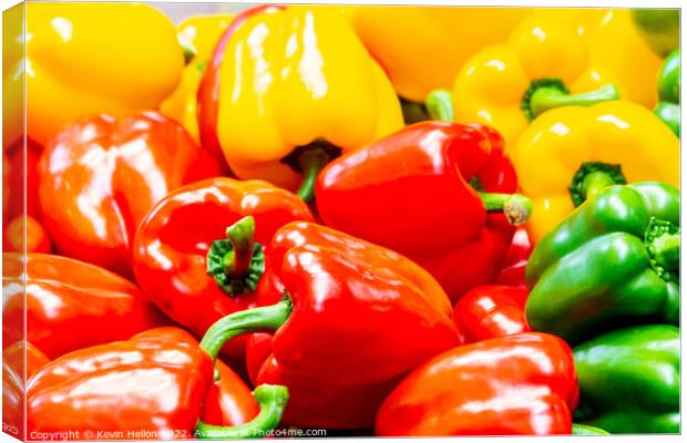 Red, yellow and green peppers on a market stall Canvas Print by Kevin Hellon