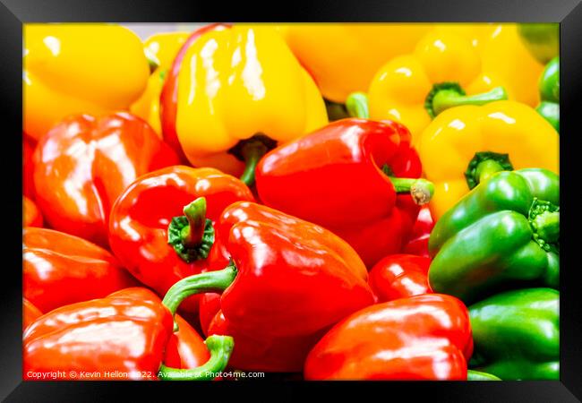 Red, yellow and green peppers on a market stall Framed Print by Kevin Hellon