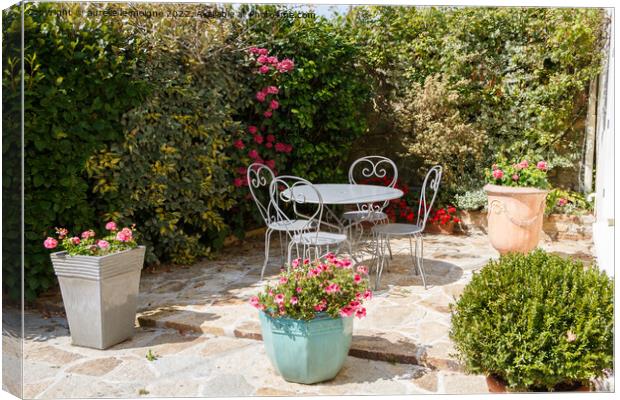 Flowered terrace with garden furniture Canvas Print by aurélie le moigne
