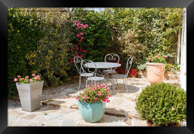 Flowered terrace with garden furniture Framed Print by aurélie le moigne