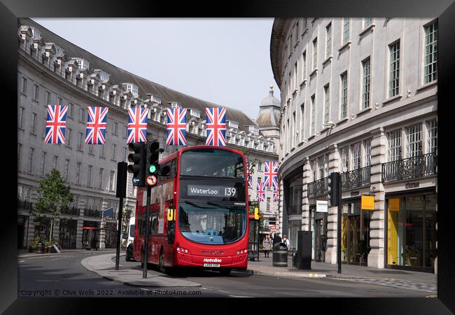 London bus under the flags Framed Print by Clive Wells