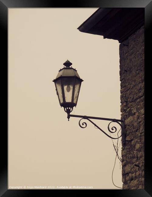 Closeup of a vintage wall-mounted lantern in the light background Framed Print by Ingo Menhard