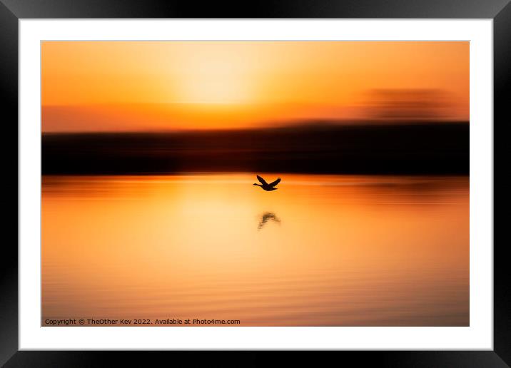 bird flying over a lake in an orange sunrise Framed Mounted Print by TheOther Kev