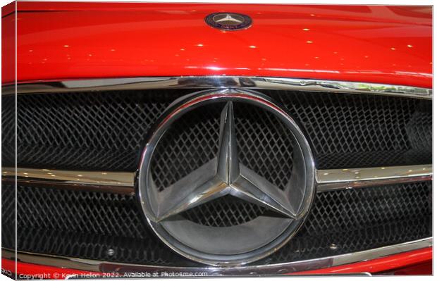 Mercedes badge on a red car. Canvas Print by Kevin Hellon