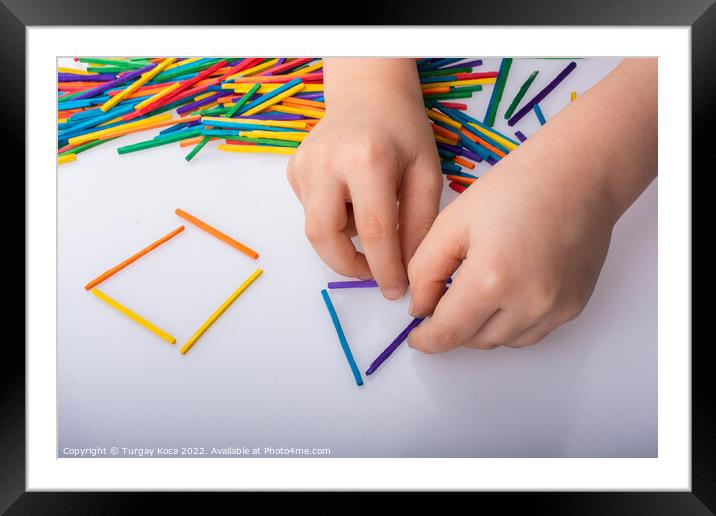 Kid making geometric shapes with colorful sticks o Framed Mounted Print by Turgay Koca