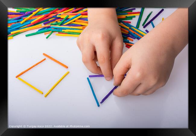 Kid making geometric shapes with colorful sticks o Framed Print by Turgay Koca