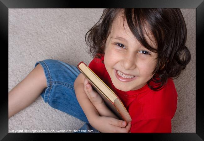 Boy holding book as World book day concept Framed Print by Turgay Koca