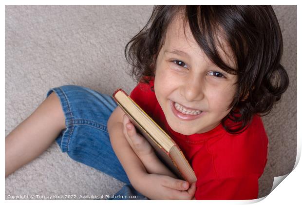 Boy holding book as World book day concept Print by Turgay Koca