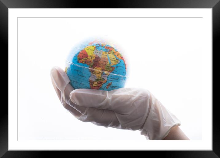 Hand with gloves holding globe  corona virus flu o Framed Mounted Print by Turgay Koca