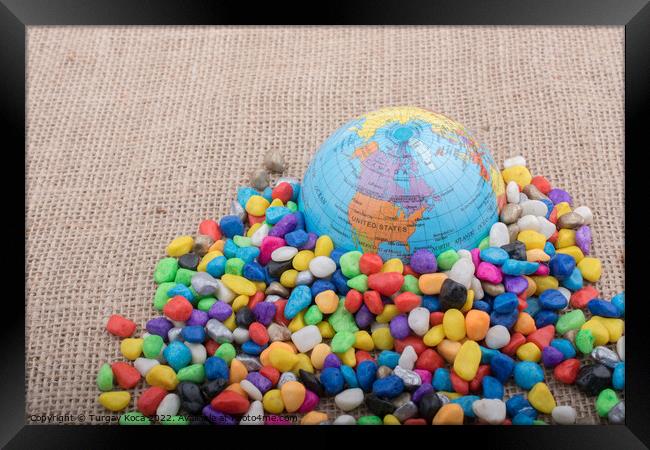 Little model globe amid colorful pebbles  Framed Print by Turgay Koca