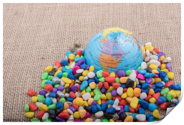 Little model globe amid colorful pebbles  Print by Turgay Koca