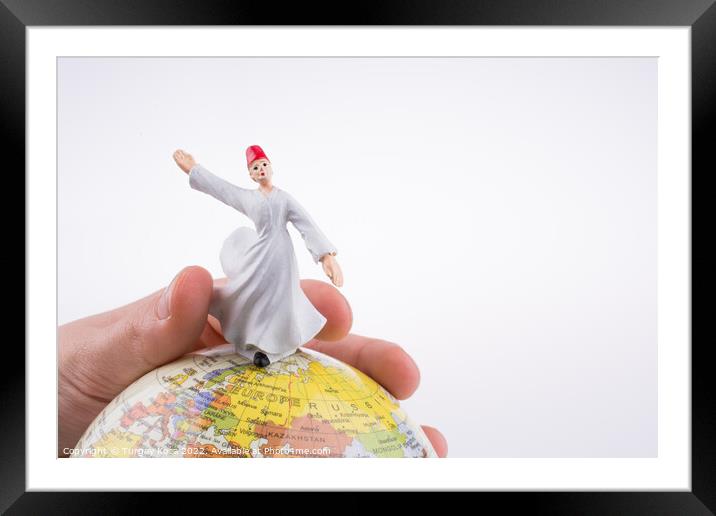 Hand holding a Derviş on a globe Framed Mounted Print by Turgay Koca