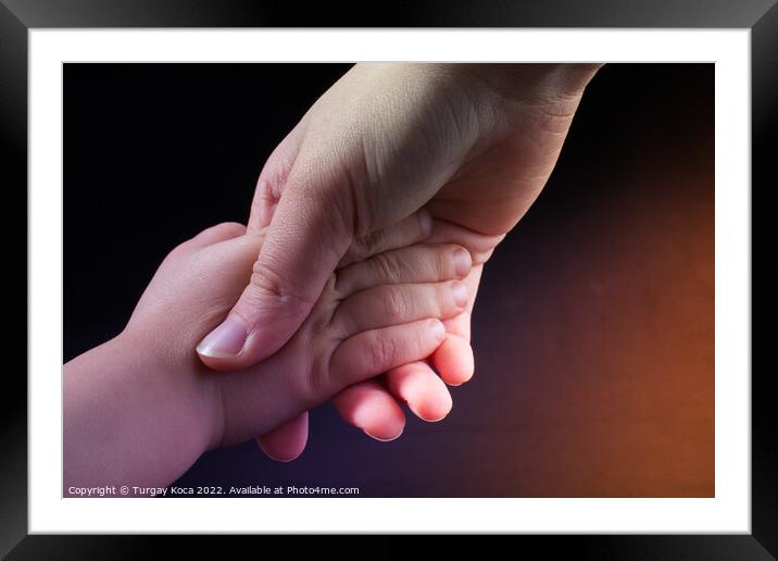 Adult and child hold hands Framed Mounted Print by Turgay Koca