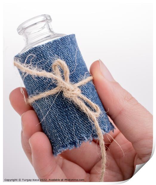 Little bottle covered with canvas in hand Print by Turgay Koca
