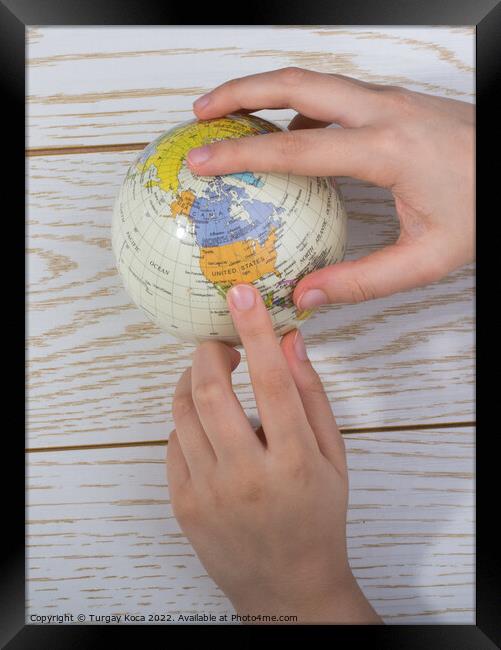Hand holding a globe  with the map on it Framed Print by Turgay Koca