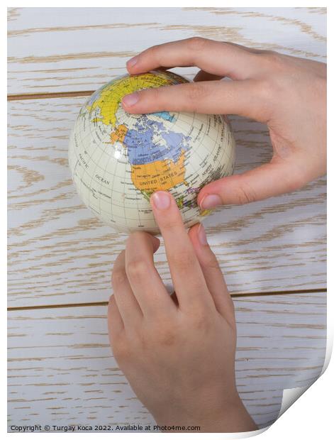 Hand holding a globe  with the map on it Print by Turgay Koca