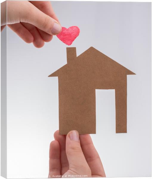 Hand holding a heart on a paper house  Canvas Print by Turgay Koca