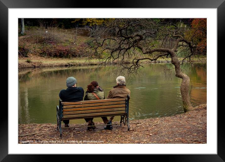 People seat on wooden bench by the lake in nature Framed Mounted Print by Turgay Koca