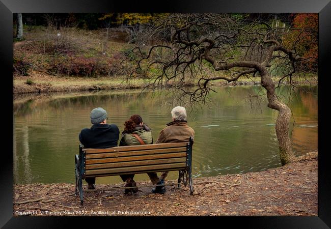 People seat on wooden bench by the lake in nature Framed Print by Turgay Koca