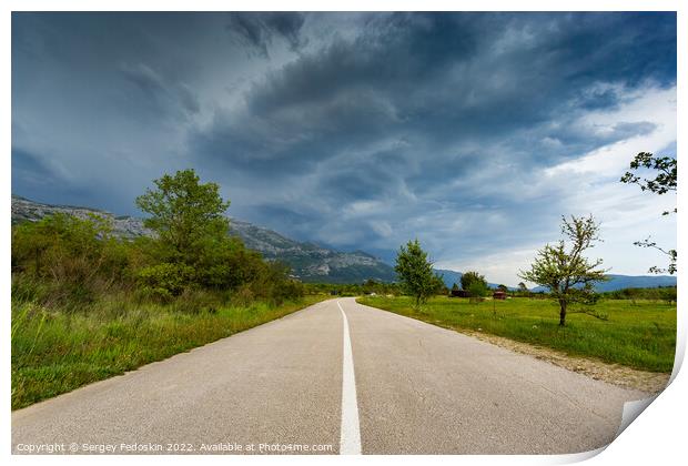 Empty countryside road in valley. Landscape with dramatic sky. A storm is coming from the mountains. Print by Sergey Fedoskin