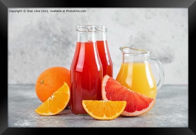 Glass pitchers of grapefruit juice with slices of orange fruits Framed Print by Stan Lihai