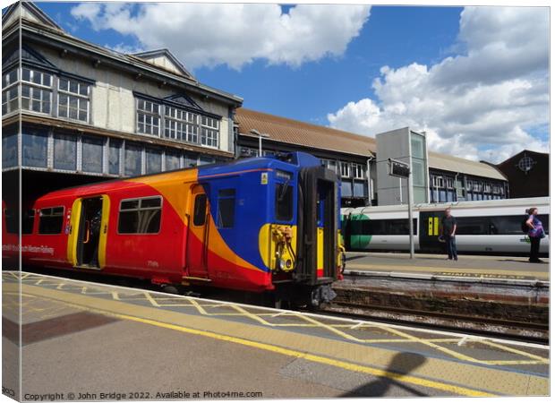 SWR Train at Clapham Junction  Canvas Print by John Bridge