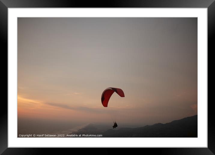 Tandem paragliding over sea and beach at sunset Framed Mounted Print by Hanif Setiawan