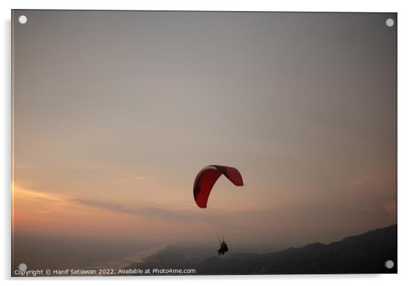 Tandem paragliding over sea and beach at sunset Acrylic by Hanif Setiawan