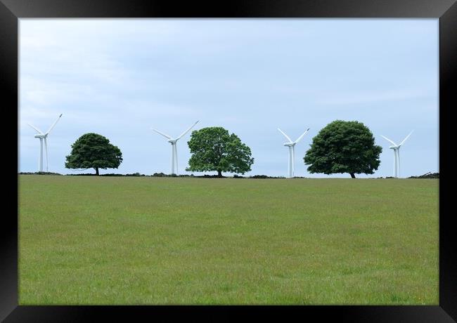Windmills between the trees Framed Print by Roy Hinchliffe