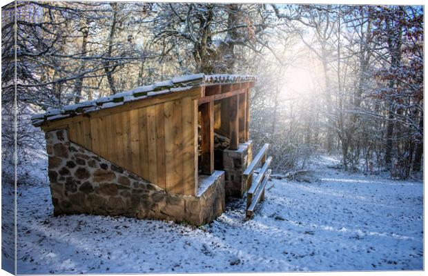 wood and stone cabin in the snowy forest at sunrise at sunrise Canvas Print by David Galindo