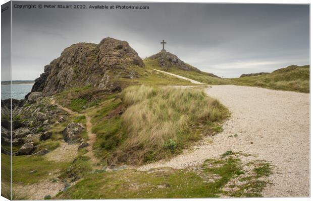 The stone cross overlooks the Llanddwyn beaches and lighthouses  Canvas Print by Peter Stuart