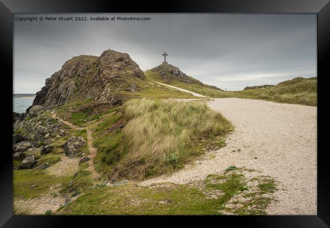 The stone cross overlooks the Llanddwyn beaches and lighthouses  Framed Print by Peter Stuart