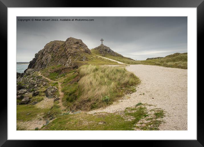 The stone cross overlooks the Llanddwyn beaches and lighthouses  Framed Mounted Print by Peter Stuart