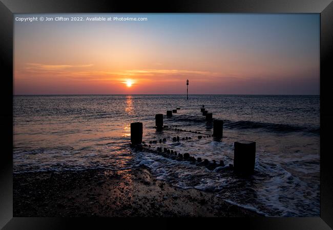 A sunset over a body of water Framed Print by Jon Clifton