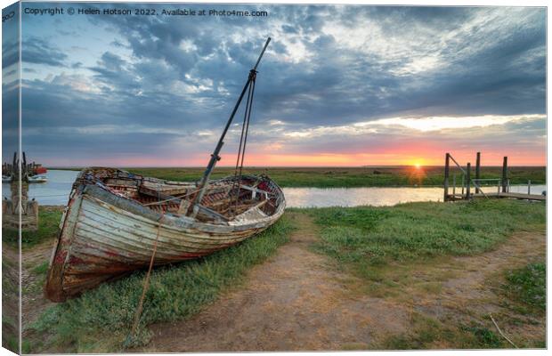 Sunrise over an old fishing boat on the shore at Thornham Canvas Print by Helen Hotson