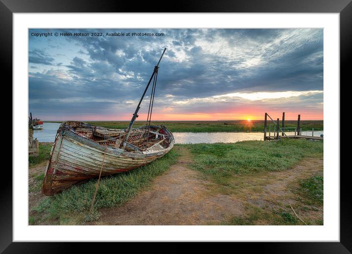 Sunrise over an old fishing boat on the shore at Thornham Framed Mounted Print by Helen Hotson