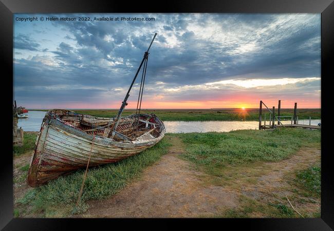Sunrise over an old fishing boat on the shore at Thornham Framed Print by Helen Hotson