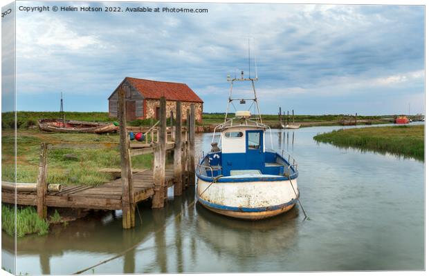 A fishing boat moored at a wodden jetty at Thornham Canvas Print by Helen Hotson