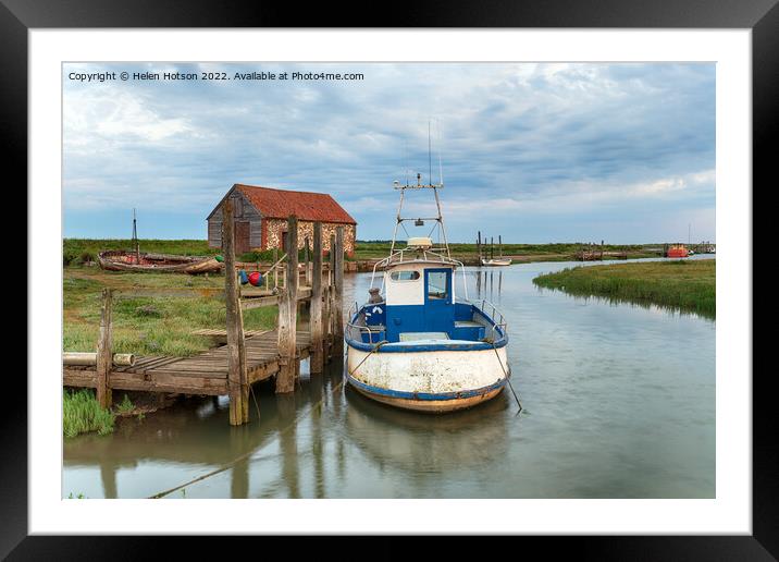 A fishing boat moored at a wodden jetty at Thornham Framed Mounted Print by Helen Hotson