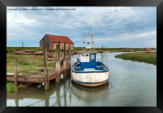 A fishing boat moored at a wodden jetty at Thornham Framed Print by Helen Hotson