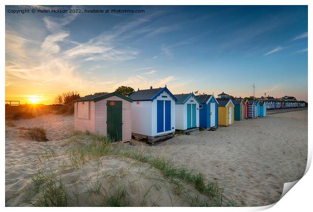 Sunset over a row of beach huts at Southwold  Print by Helen Hotson