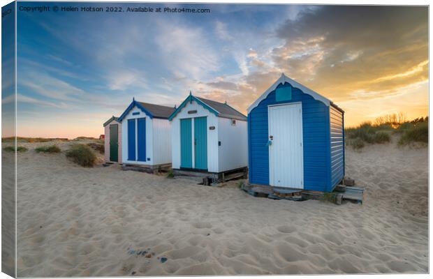 Sunset over a row of pretty beach huts at Southwold  Canvas Print by Helen Hotson